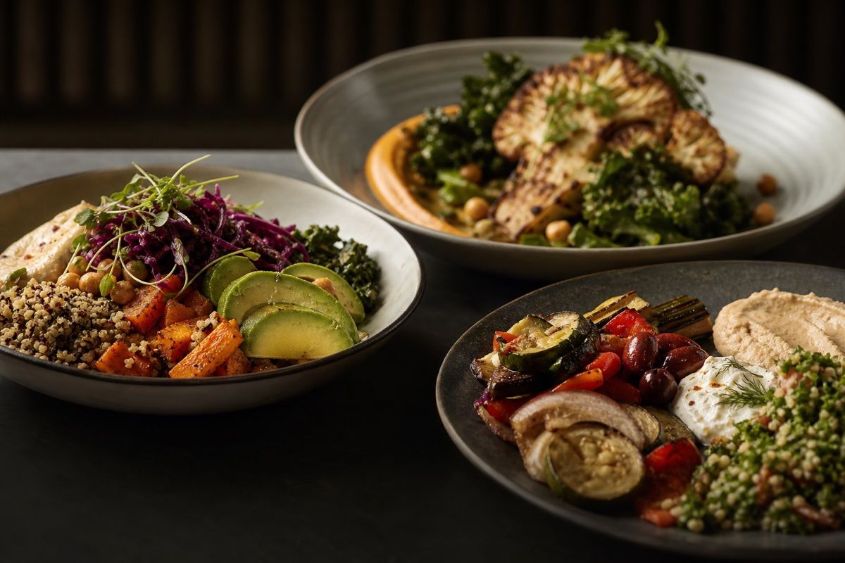 Three freshly prepared bowls with vegetables and side dishes